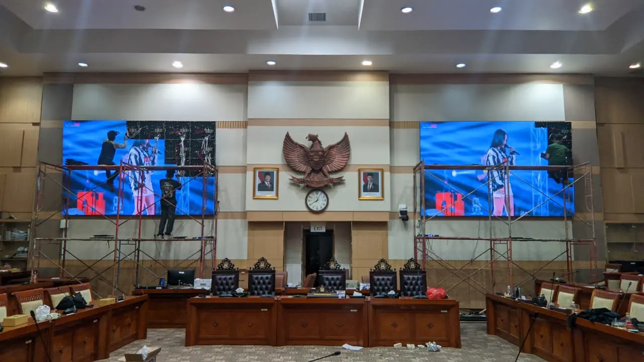 Teknisi melakukan commissioning dan pengujian videotron indoor di ruang sidang setelah proses instalasi selesai