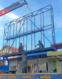 Proses konstruksi videotron outdoor menggunakan crane pada pemasangan rangka besi